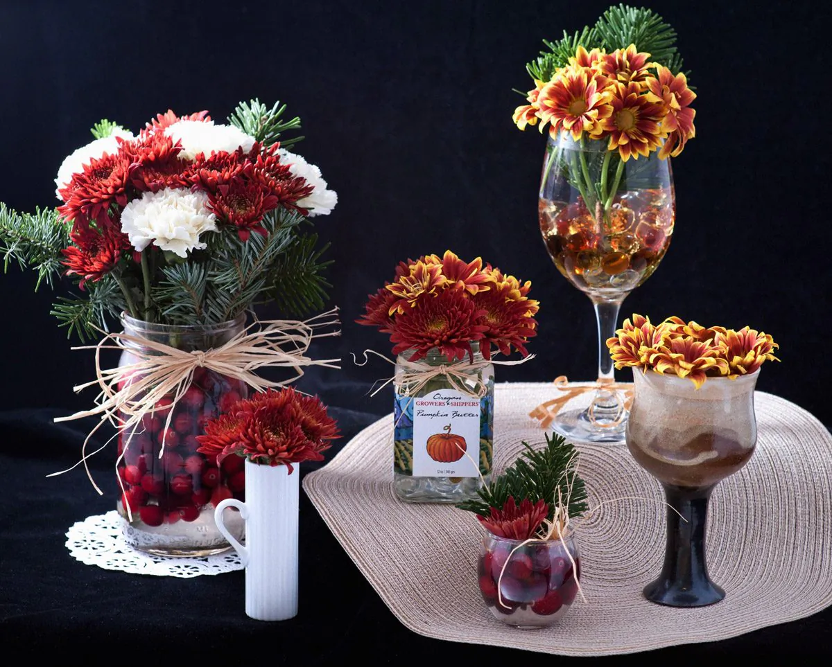 Holiday flower arrangements using one flower bouquet, fresh cranberries, and various mini-vases. (Cat Rooney/Epoch Times)