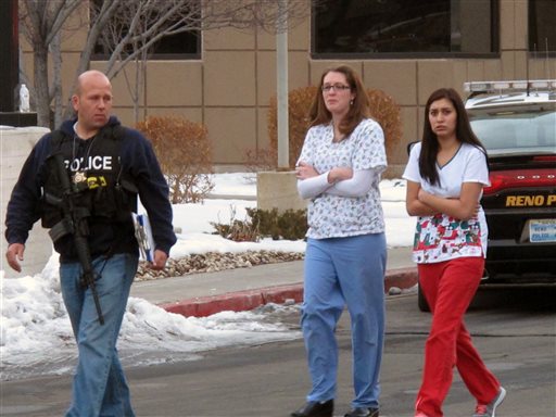 Police escort hospital staff away from a medical office building in Reno, Nev., on Tuesday, Dec. 17, 2013. A suicidal gunman killed one person and critically wounded two others before turning the gun on himself on the grounds of Renown Regional Medical Center Tuesday. (AP Photo/Scott Sonner).