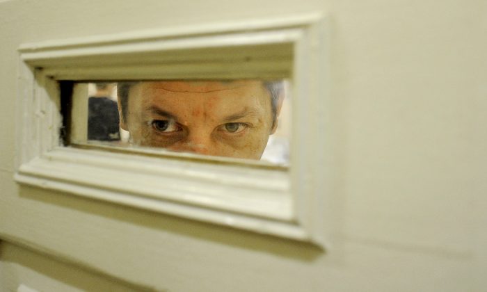 A patient looks through a window of the door in the Serbsky State Scientific Center for Social and Forensic Psychiatry, which has called for mandatory treatment of alcoholism and drug abuse. Moscow, Oct. 10, 2011. (Natalia Kolesnikova/AFP/Getty Images)