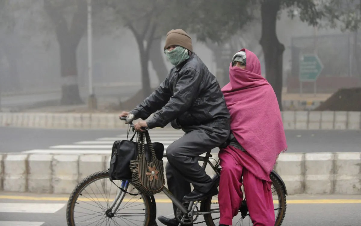 An Indian couple travel on a bicycle through dense fog in New Delhi; the city is currently experiencing winter chill. The new government has decided to convert abandoned buses into winter shelters for homeless people.(Raveendran/AFP/Getty Images)
