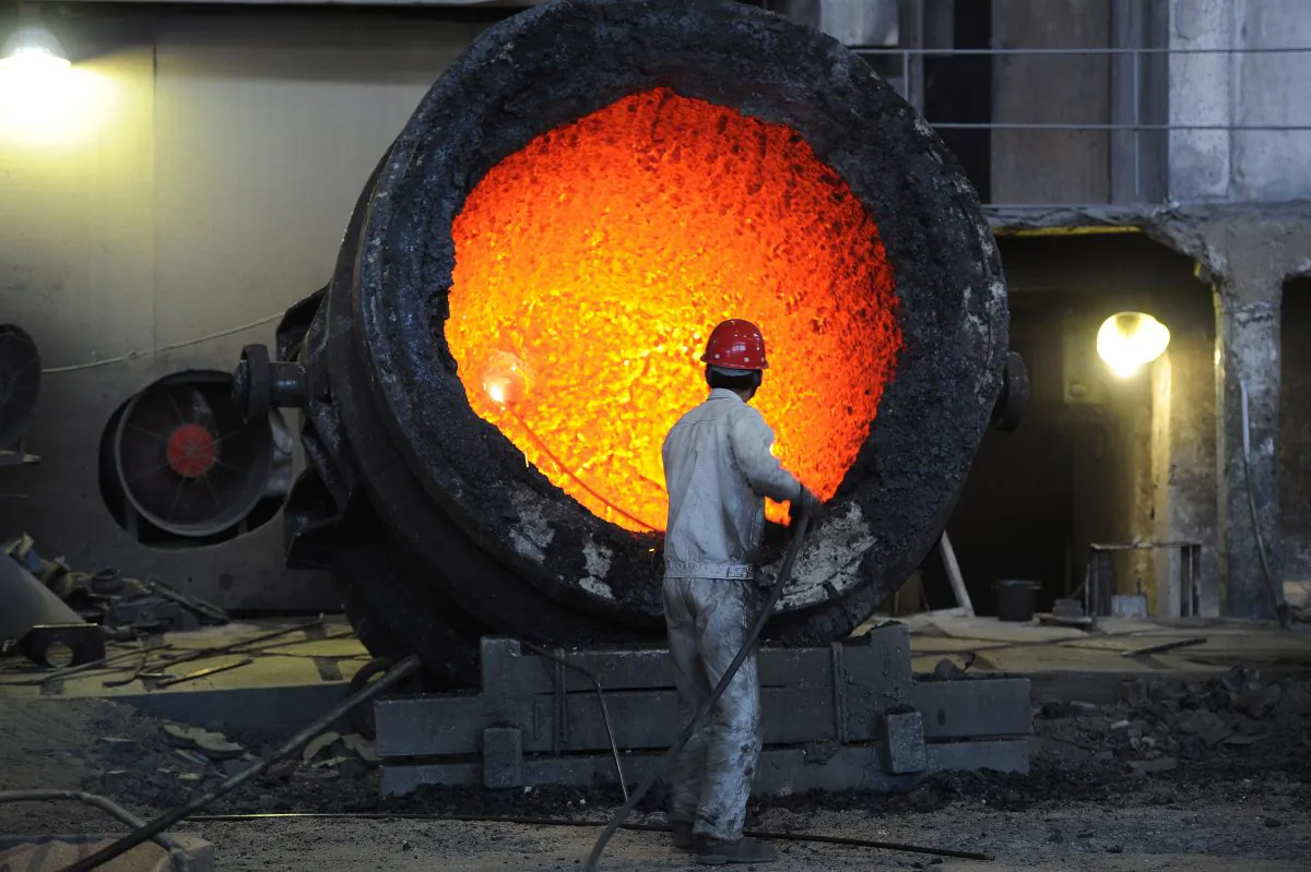 In this file photo a worker stokes a giant burning cauldron at a steel mill in Hefei, in eastern China's Anhui province, on June 25, 2011. Overcapacity in steel and other industries is one of the major challenges facing China's economy in 2014. (STR/AFP/Getty Images)