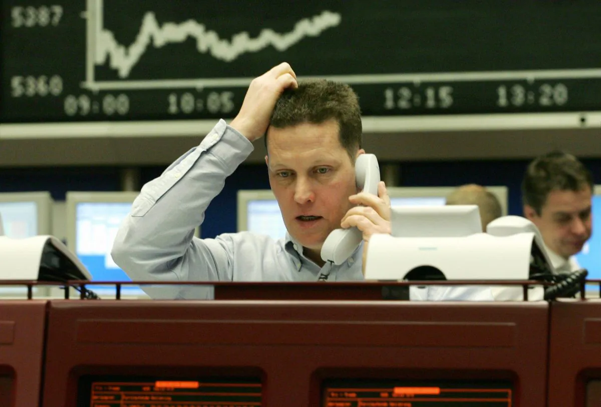 A trader sitting in front of a stock chart at a stock exchange gestures as he speaks on the phone in this file photo. Look on weakness in a stock as cause for concern and further investigation. But don’t sell just because a stock went down. (Thomas Lohnes/AFP/Getty Images)