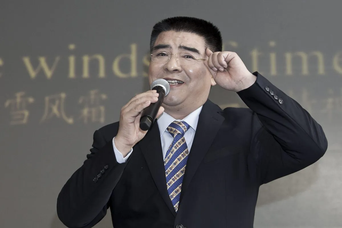 Chen Guangbiao sings karaoke at a press conference he called for the morning of Tuesday, Jan. 7, 2014, in a hotel in New York City. Lyrics to the song he is singing, in Chinese and English, were projected onto the wall behind him. (Samira Bouaou/Epoch Times)