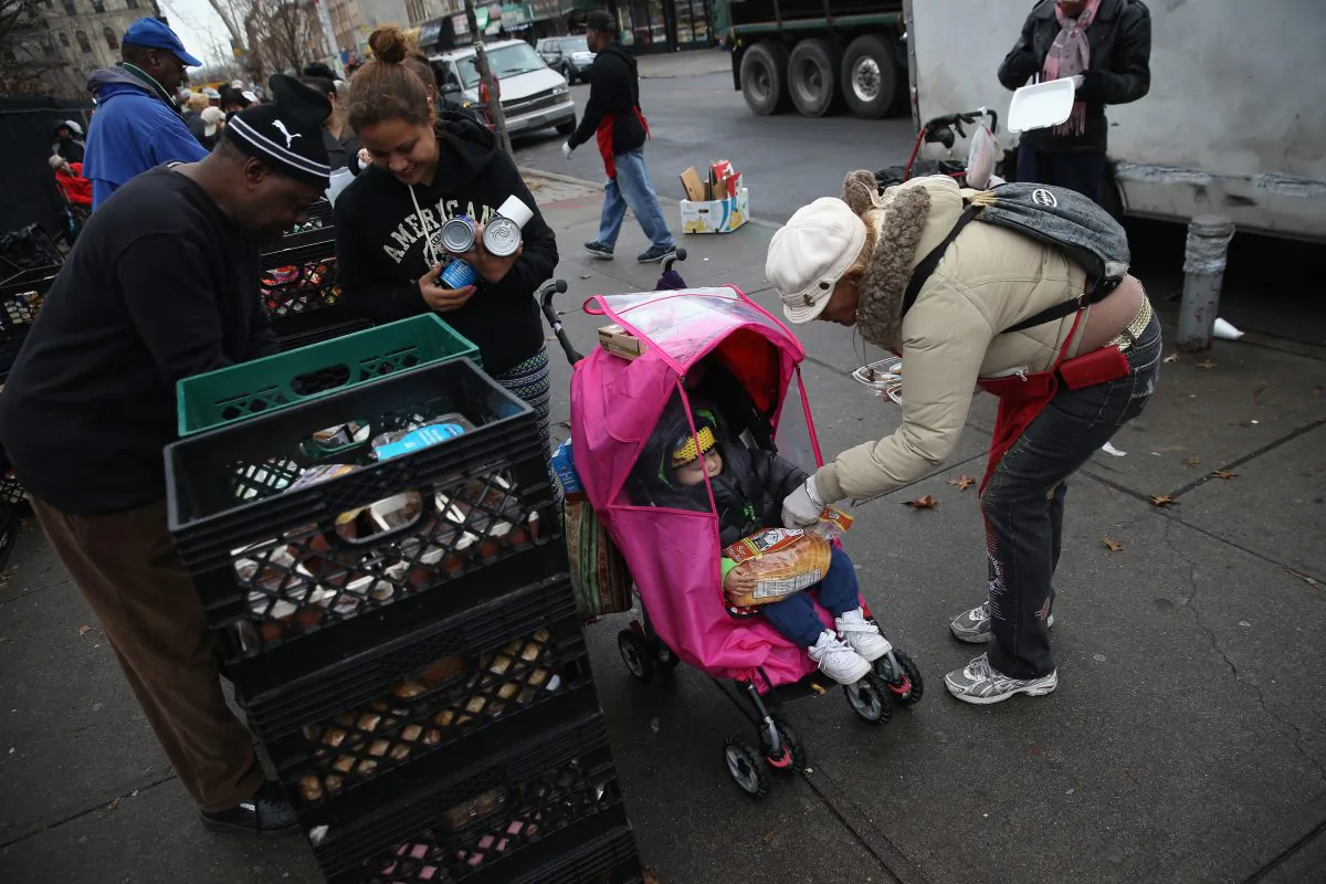Residents receive free food as part of a Bowery Mission outreach program in Brooklyn, New York, on Dec, 5, 2013. The Christan ministry said it has seen a spike in need since food stamps to low-income families were reduced in November with cuts to the federal Supplemental Nutrition Assistance Program. (John Moore/Getty Images) 