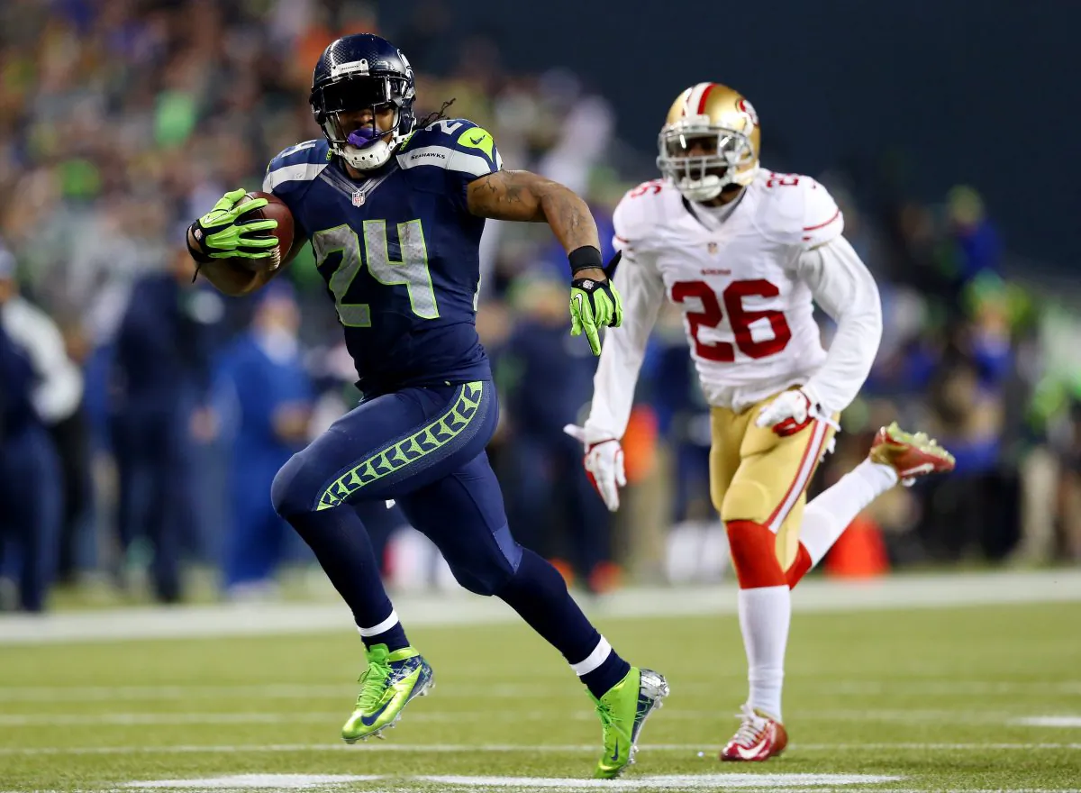 Running back Marshawn Lynch #24 of the Seattle Seahawks scores a 40-yard touchdown against cornerback Tramaine Brock #26 of the San Francisco 49ers in the third quarter during the 2014 NFC Championship at CenturyLink Field in Seattle, Washington, January 19, 2014. (Ronald Martinez/Getty Images)