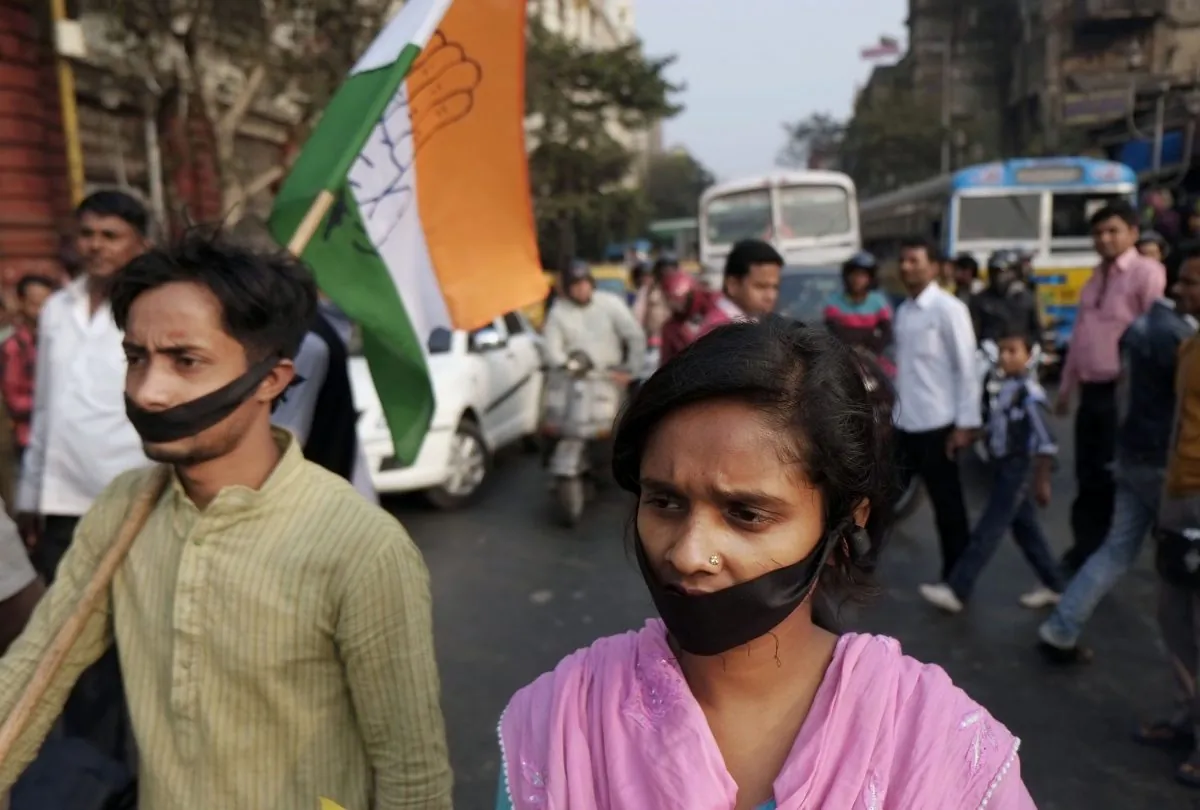 Activists of Indian National Congress with black bands around their mouth block traffic during a protest against a gang-rape and murder of a 16-year-old girl at Madhyamgram, about 25 kilometers (16 miles) north of Kolkata, India, Friday, Jan. 3, 2014. On Dec. 31 the girl set herself on fire and died due to burn injuries after being raped twice in October. The death of the girl has sparked outrage in the metropolis. (AP Photo/Bikas Das)