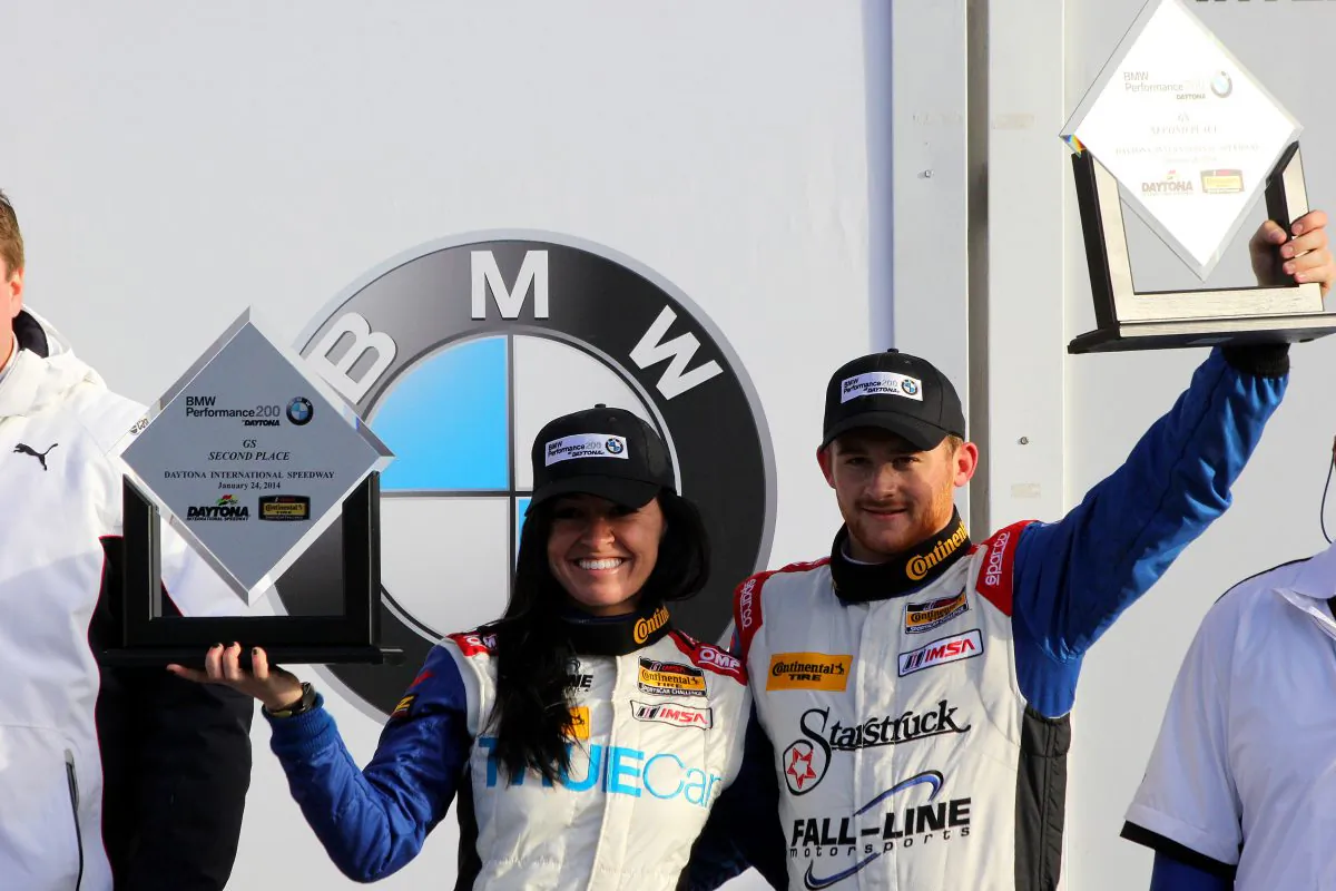 Ashley Freiberg and Shelby Blackstock raise their second place trophies at the podium ceremony following the CTSCC BMW Performance 200 at Daytona Friday. The pair was later awarded the win. (Chris Jasurek/Epoch Times)