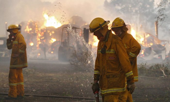 Country Fire Authority (CFA) volunteers prepare to move to save another house during the 2009 Black Saturday bushfires in Victoria. The fires destroyed over 2000 houses and came perilously close to outer Melbourne suburbs. (William West/AFP/Getty Images)
