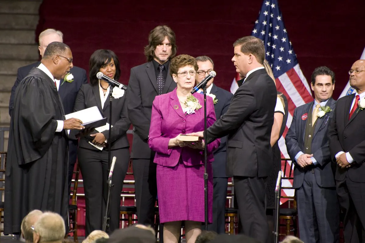 Martin J. Walsh takes the oath of office administered by Mass. Supreme Court Chief Justice Roderick L. Ireland at the Boston College Conte Forum in Boston, Mass., on Jan. 6. Walsh's left hand is on a Bible held by his mother, Mary Walsh. (Te Chen/Epoch Times)