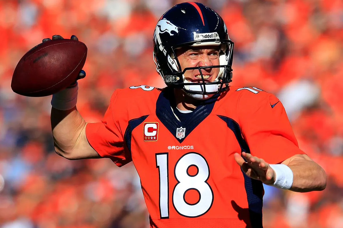 Denver Broncos quarterback #18 Peyton Manning looks to pass against the New England Patriots during the AFC Championship game at Sports Authority Field at Mile High in Denver, Colorado on January 19, 2014. (Jamie Squire/Getty Images)