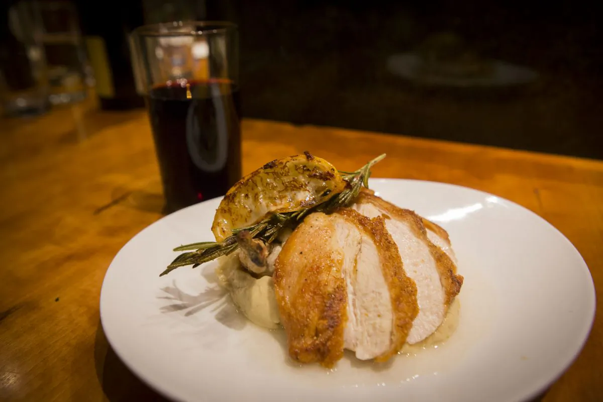Crispy roasted organic chicken breast with fresh herbs and celery root purée, with organic Barbera wine. (Courtesy of Ellary's Greens)