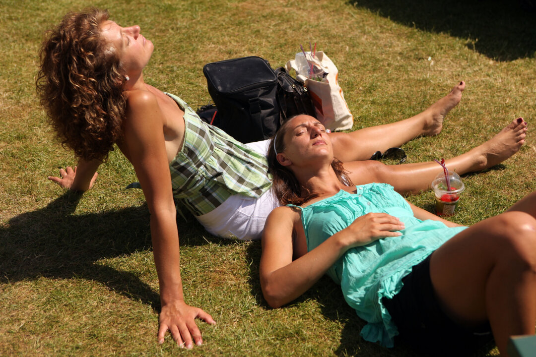 Spectators sunbathe at Wimbledon Lawn Tennis Championships on June 28th, 2010, in London. New research finds that exposure to sunlight lowers blood pressure. (Oli Scarff/Getty Images)