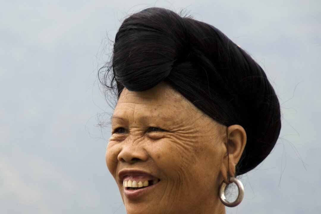 A Yao woman displays her hair styled in a bun over her forehead. The Yao women believe that the fermented rice water helps keep their hair black up past the age of 80. (Tim Whiteaker)