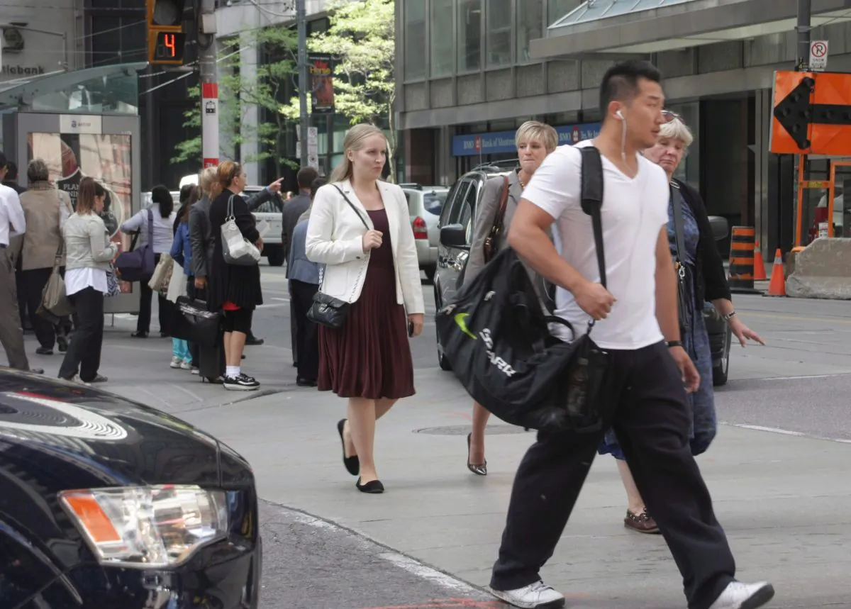 Office workers and other pedestrians cross an intersection in downtown Toronto.
(The Canadian Press/Colin Perkel)