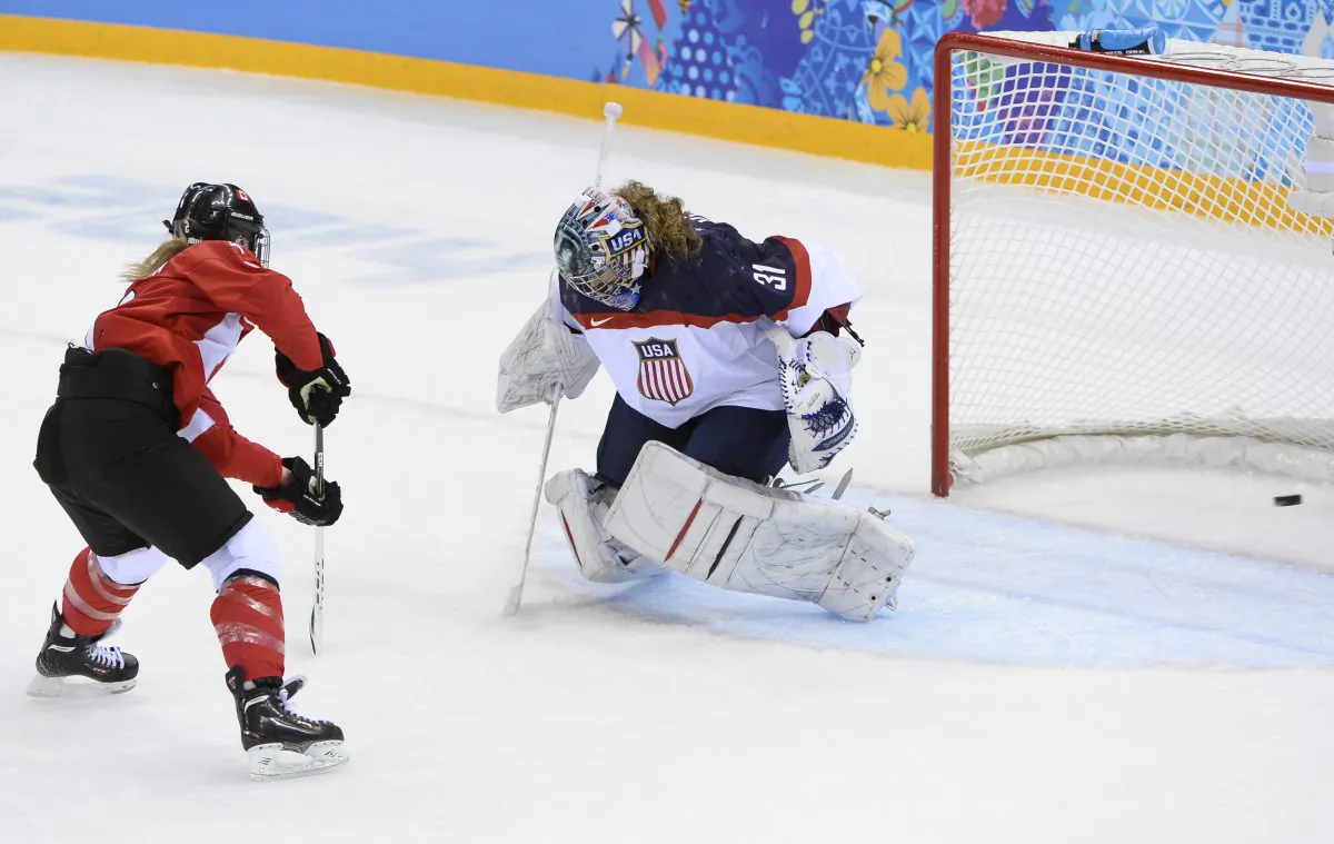 Canada's Meghan Agosta-Marciano (L) scores a goal past U.S. goalkeeper Jessie Vetter during the Women's Ice Hockey Group A match between Canada and USA at the Sochi Winter Olympics on February 12, 2014 at the Shayba Arena. (Jonathan Nackstrand/AFP/Getty Images)