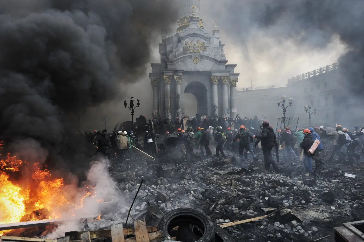 Protesters advance towards new positions in Kyiv on Feb. 20, 2014. Armed protesters stormed police barricades in Kyiv on Thursday in renewed violence that killed at least 26 people and shattered an hours-old truce as EU envoys held crisis talks with Ukraine's embattled President Viktor Yanukovych. Bodies of anti-government demonstrators lay amid smouldering debris after masked protesters hurling Molotov cocktails and stones forced police from Kyiv's iconic Independence Square—the epicenter of the ex-Soviet country's three-month-old crisis. (Louisa Gouliamaki/AFP/Getty Images)