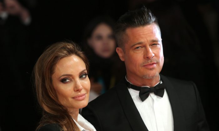 Actors Angelina Jolie and Brad PItt pose for photographers on the red carpet at the EE British Academy Film Awards held at the Royal Opera House on Sunday Feb. 16, 2014, in London. (Joel Ryan/Invision/AP)