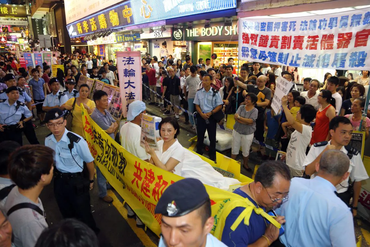 HKYCA members are harassing a Falun Gong demonstration by using yellow slanderous banners to cover Falun Gong practitioners, who are demonstrating to raise awareness of live organ harvesting—the most inhuman crime now happening in China. The alerted police do not take any action to enforce the law. The general public consider this a typical example of selective law enforcement of the Leung government. (Epoch Times)
