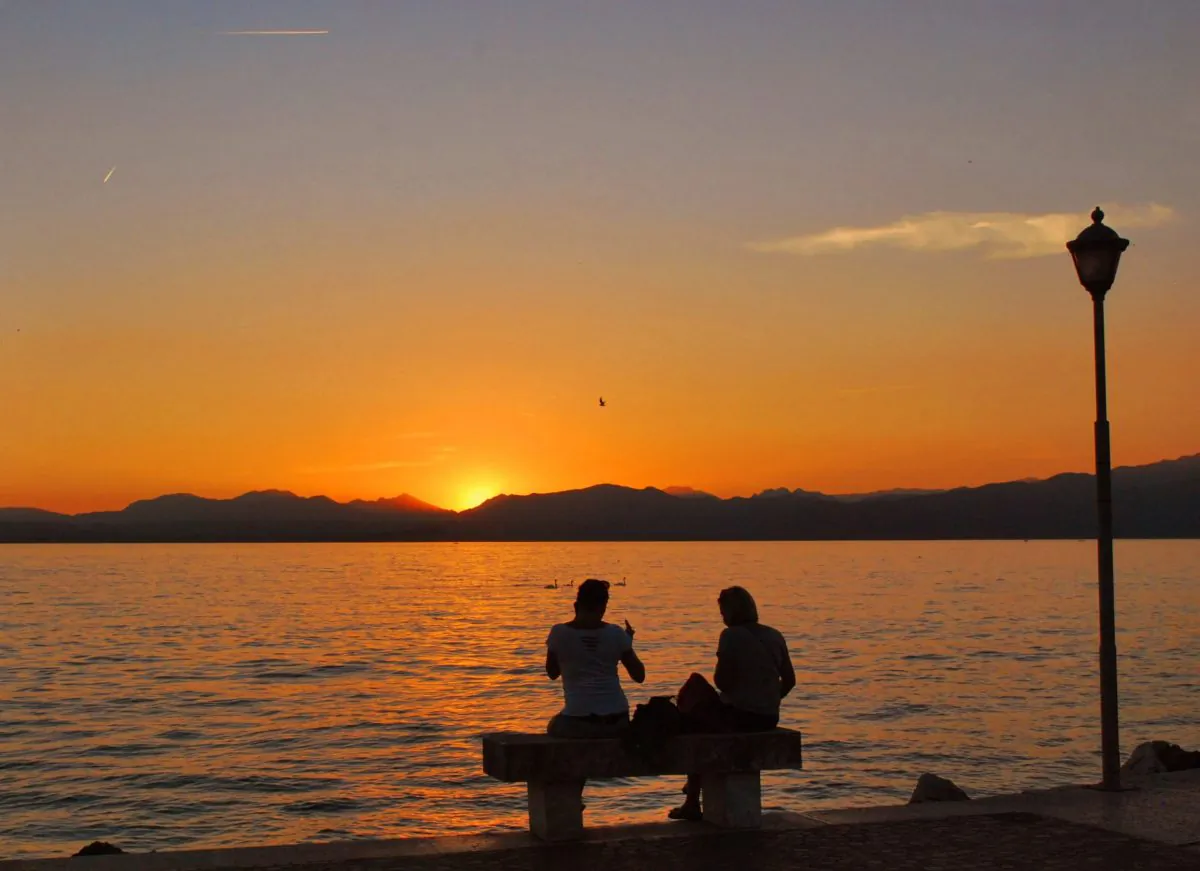 Two girls contemplating the sunset on Lake Garda. (Marius Iacob/Epoch Times)