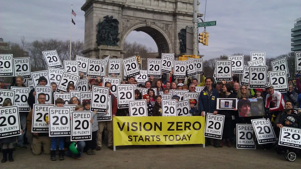 Community members hold signs, reading  "20 is Plenty," in support of New York state legislation to lower New York City speed limits to 20 mph, in Prospect Park, Brooklyn, New York, Feb. 2, 2014. (Catherine Yang/Epoch Times)