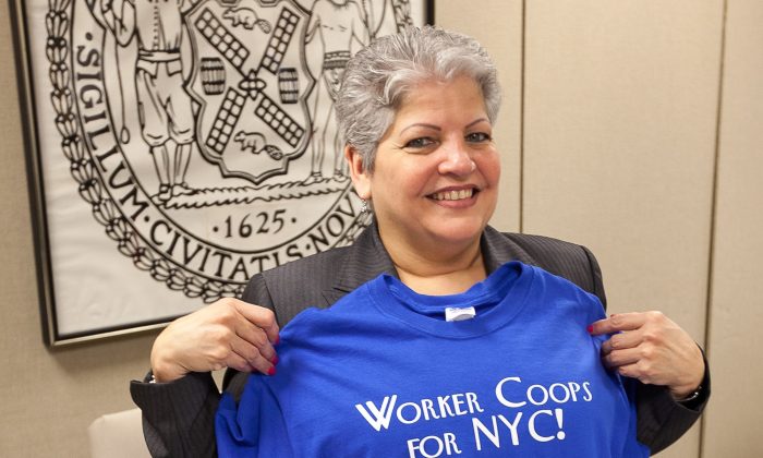 Community Development Committee Chair Maria Carmen del Arroyo proudly displays a workers co-op T-shirt in New York on Feb. 22, 2014. (Epoch Times)
