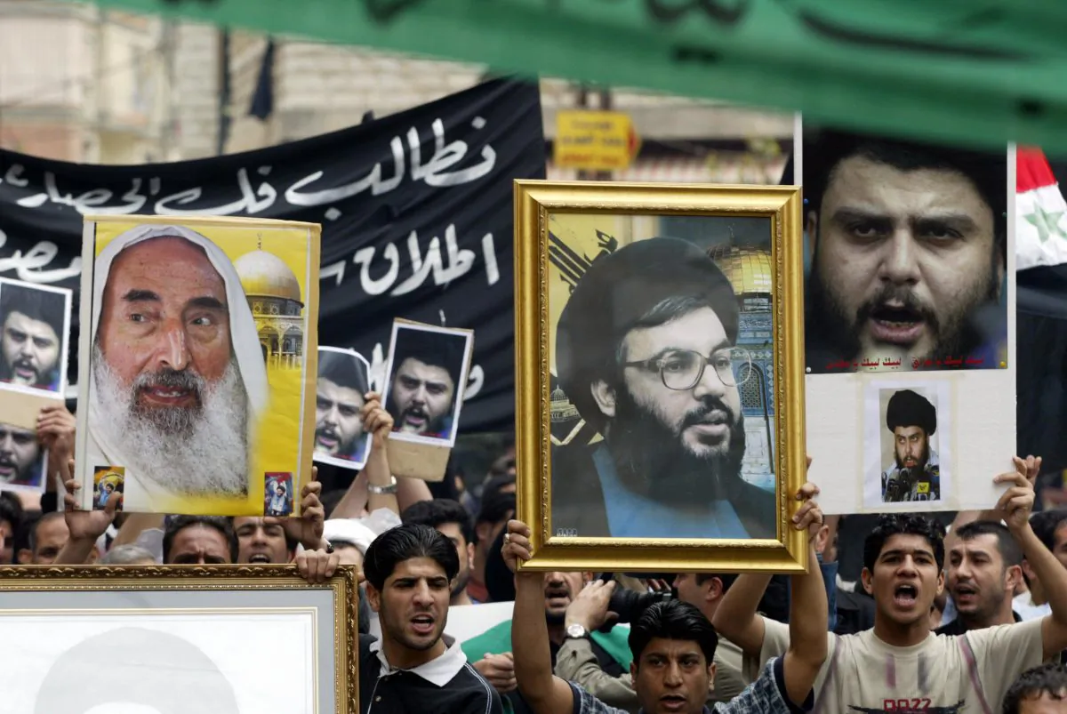 Iraqis Shiite protesters carry up pictures of late Hamas spiritual leader Sheikh Ahmed Yassin (L), Hezbollah secretary general Sheikh Hassan Nasrallah (C) and Iraqi Shiite cleric Moqtada al-Sadr during a demonstration in support of Sadr on 6 April, 2004, in the southern suburbs of Beirut. (JOSEPH BARRAK/AFP/Getty Images)