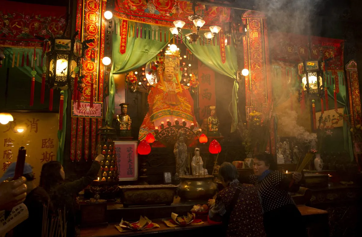 Worshippers pray and carry incense sticks at the Tin Hau Temple in the Yau Ma Tei area of Hong Kong on the fourth day of the Lunar New Year holiday on Feb. 3, 2014. During the New Year, Chinese observe various tradit