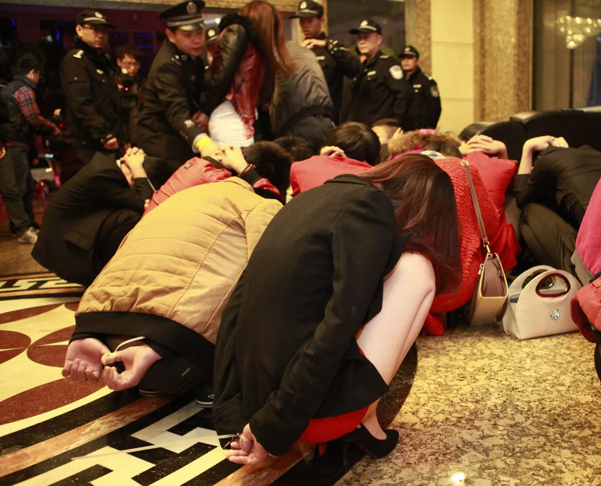 Chinese police round up alleged sex workers and clients at an entertainment center in Dongguan, in southern China's Guangdong province on Feb. 9, 2014. Raids on several venues involved in the illegal sex trade were shut down after China Central Television revealed a dozen hotels in Dongguan offered sex services. (STR/AFP/Getty Images)