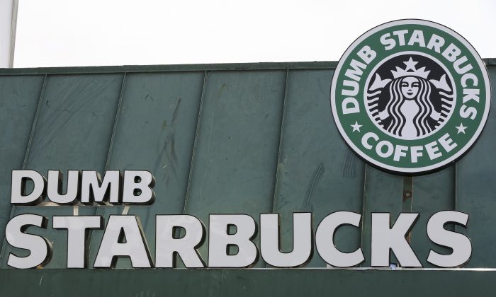 The sign at Dumb Starbucks coffee in Los Angeles, is displayed Monday, Feb. 10, 2014.  The store resembles a Starbucks with a green awning and mermaid logo, but with the word "Dumb" attached above the Starbucks sign. Spokeswoman Laurel Harper says the store is not affiliated with Starbucks and, despite the humor, the store cannot use the Starbucks name. (AP Photo/Damian Dovarganes)