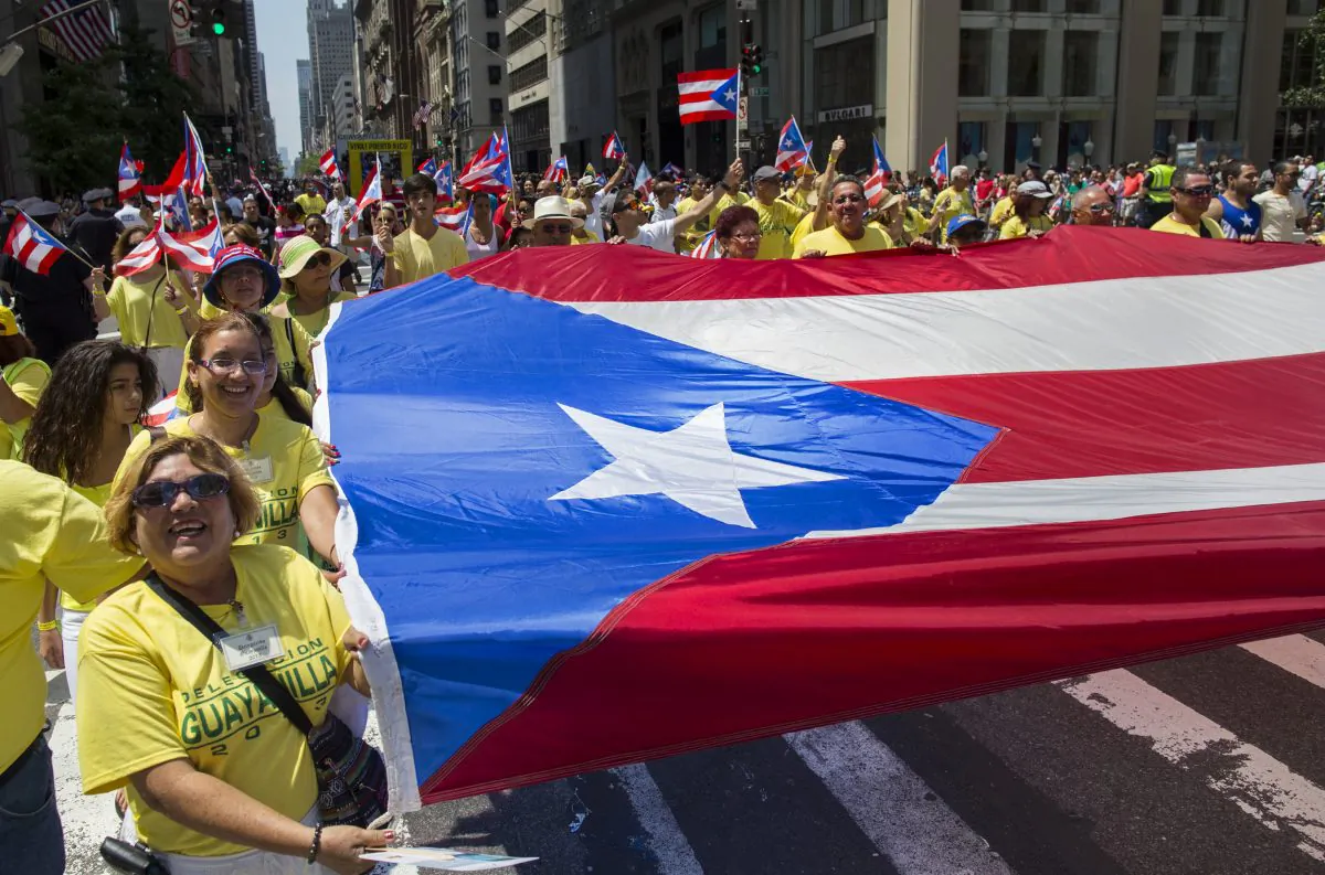 People carry a large Puerto Rican flag marching in the National Puerto Rican Day Parade in New York on June 9, 2013. (Craig Ruttle/AP)