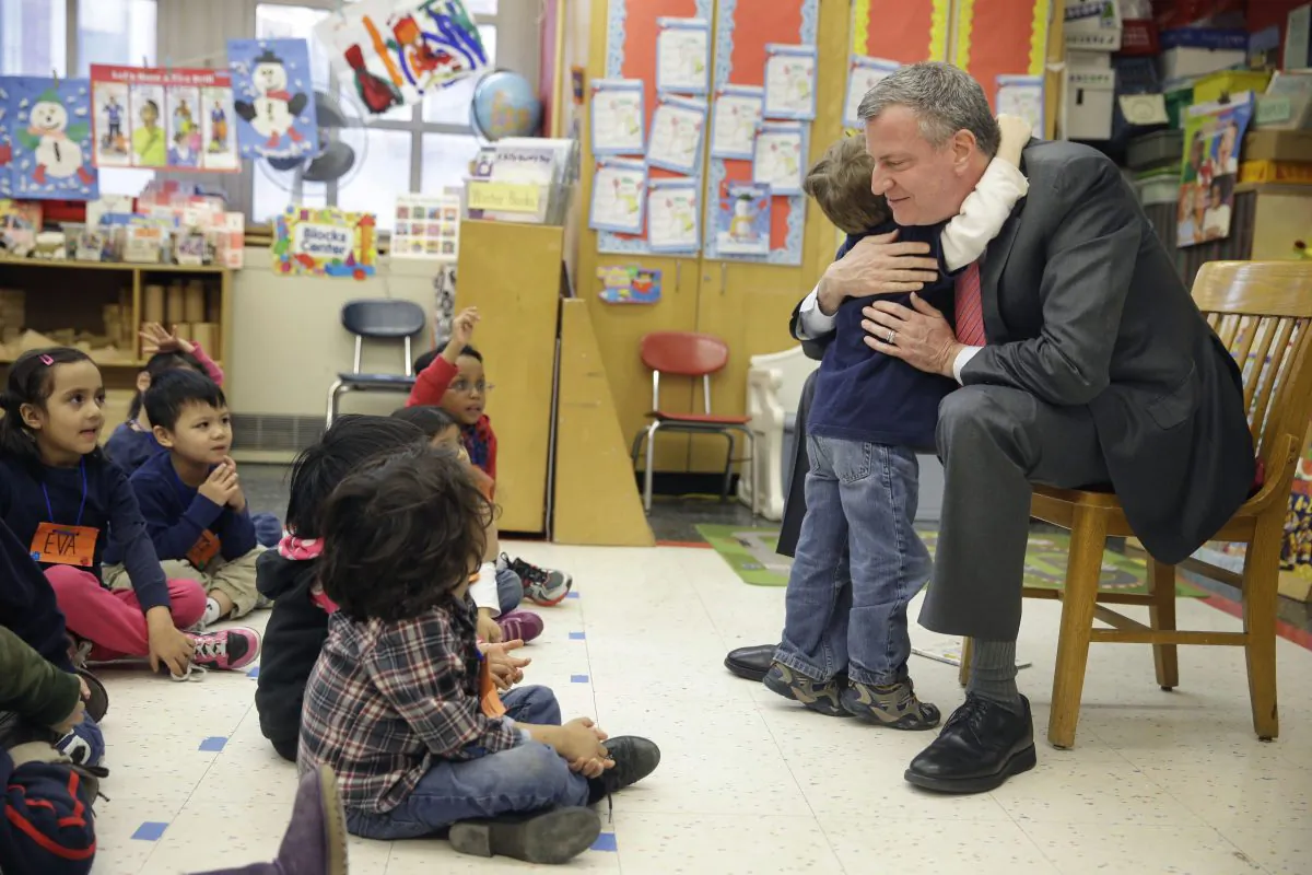 New York Mayor Bill de Blasio hugs a child after reading a book to a prekindergarten class at P.S. 130 in New York, Feb. 25, 2014. (AP Photo/Seth Wenig)