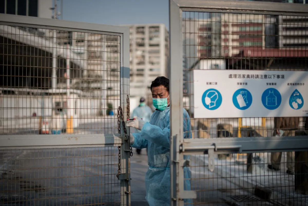 A security guard closes the gate of a live poultry market in Hong Kong on Jan. 28. There is a new outbreak of bird flu cases in China, where a new strain of the virus has re-emerged. (PHILIPPE LOPEZ/AFP/Getty Images)