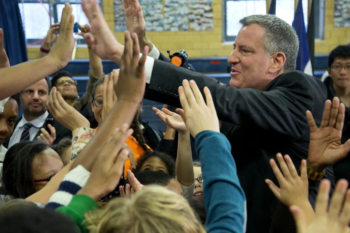 New York City Mayor Bill de Blasio exchanges high-fives with school children at M.S. 51 in Brooklyn, New York, Dec. 30, 2013. (Mark Lennihan/AP)
