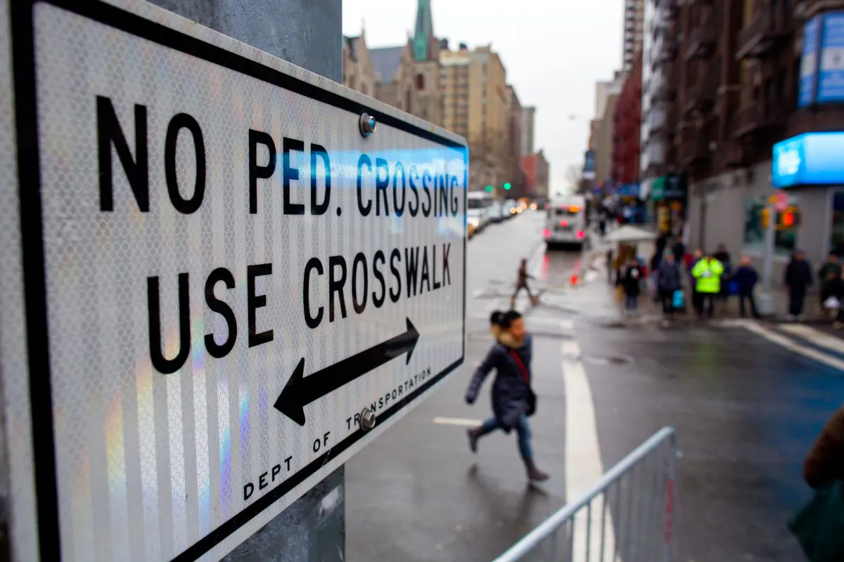 After crossing outside a crosswalk, a pedestrian runs toward a crosswalk at the busy intersection of W. 96th Street and Broadway in the Upper West Side of New York, Jan. 27, 2014. (Craig Ruttle/AP)