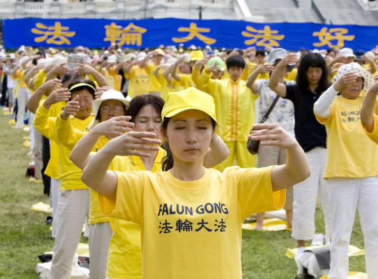 Hundreds of Falun Gong practitioners practice exercises on the grand lawn in front of the U.S. Capitol on July 12 prior to a rally highlighting the persecution of Falun Gong in China. (Ma Youzhi/The Epoch Times)