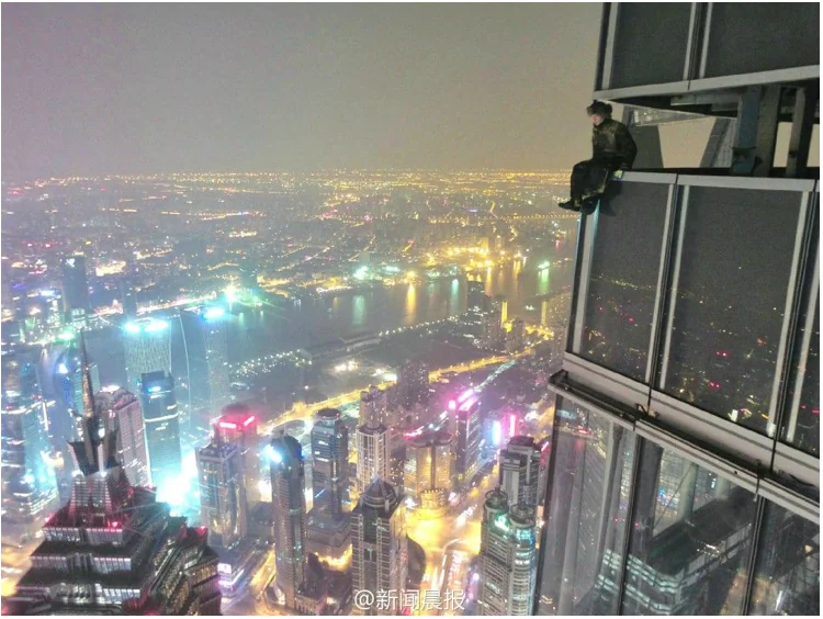 Screenshot showing one of two young Chinese men, who scaled the Shanghai Tower, China's tallest building. (Screenshot/china.org.cn)