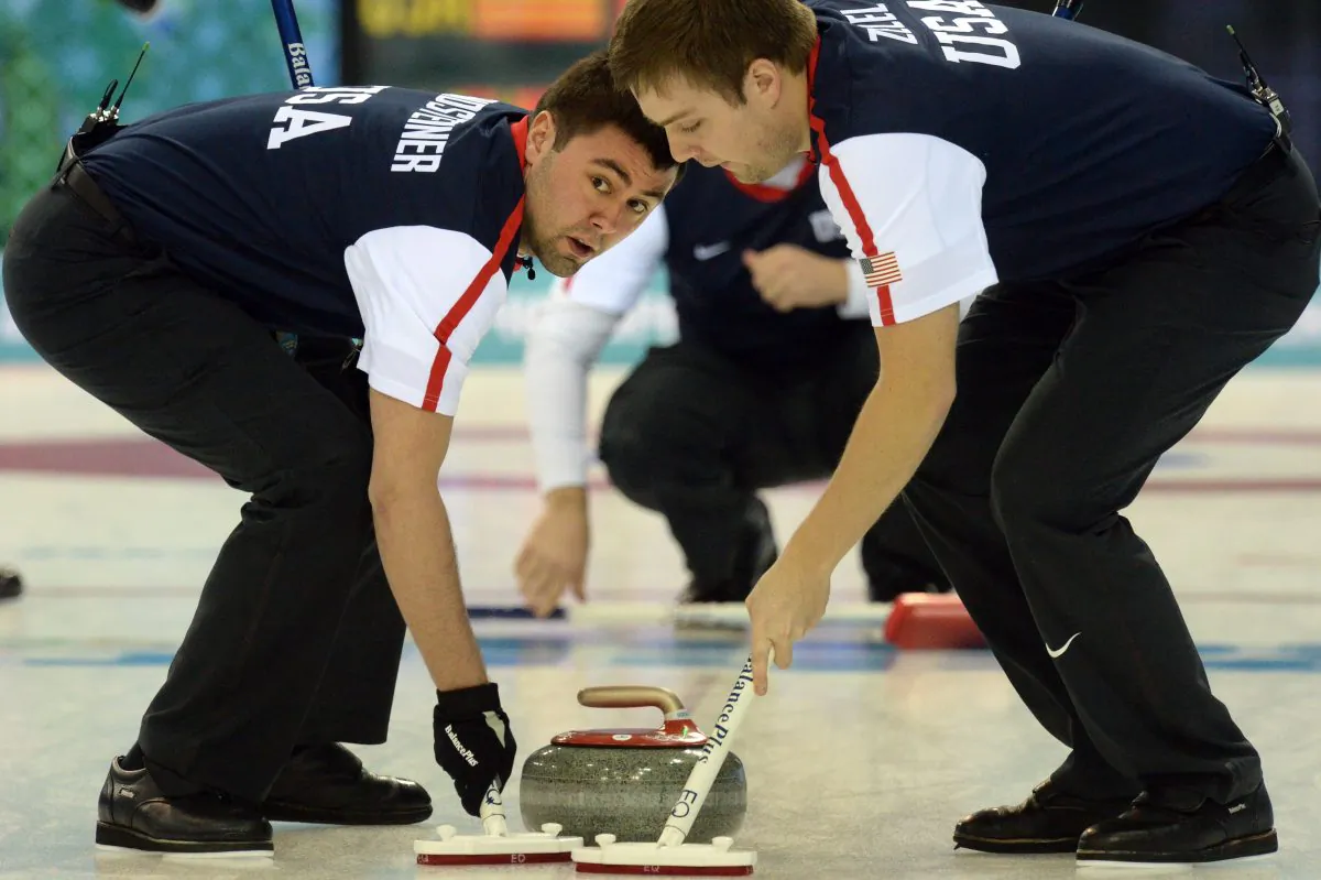 Jared Zezel (R) and John Landsteiner of the US clean the way for the stone during the men's curling round robin session 2 match between Norway and USA at the Ice Cube curling centre in Sochi on February 10, 2014 during the 2014 Sochi Winter Olympics. (Yuri Kadobnov/AFP/Getty Images)