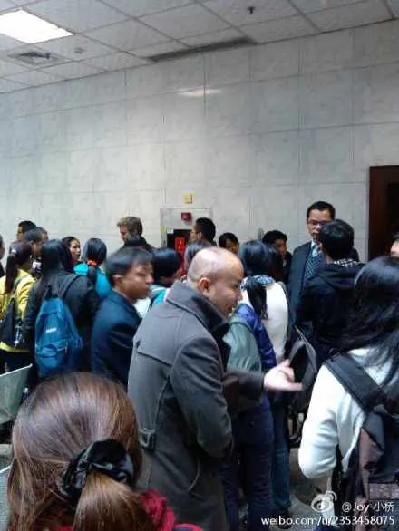 Witnesses and supporters of labor activist Wu Guijun wait outside the courtroom for his trial to open in Shenzhen, Guangzhou Province on Feb. 17, 2013. Wu's lawyer Pan Jun stands in the background behind the crowd in a suit and vest, with glasses. (Weibo.com)