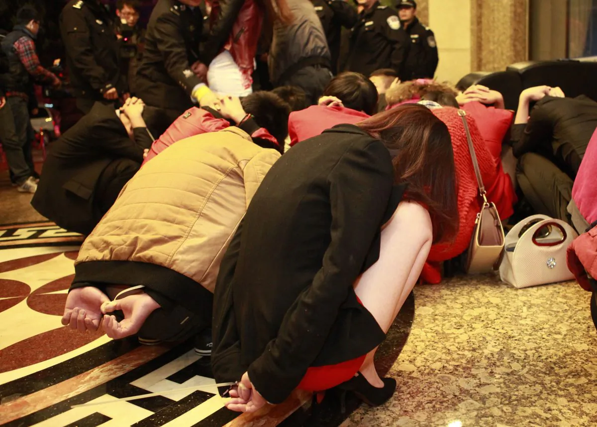 Alleged sex workers and their clients are detained by Chinese police after a raid on an entertainment center in Dongguan, in southern China's Guangdong province on Feb. 9, 2014. The crackdown is not expected to last long. (STR/AFP/Getty Images)