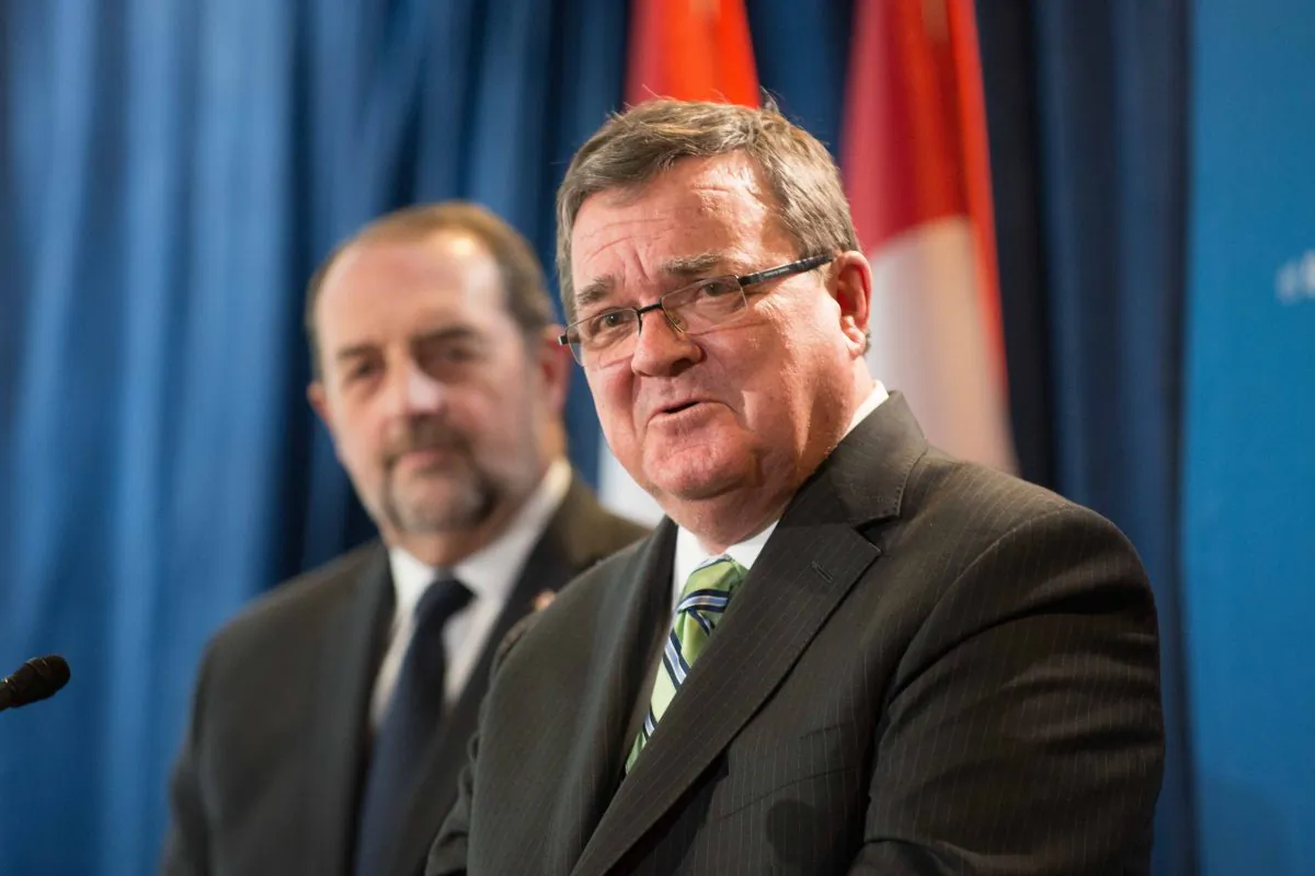Finance Minister Jim Flaherty discusses the budget on Feb. 11, 2014 at the Government Conference Centre as Infrastructure Minister Denis Lebel looks on. (Matthew Little/Epoch Times)