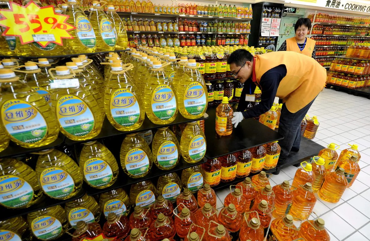 Chinese workers place bottles of cooking oil at a supermarket in Hefei, Anhui Province, China, in this file photo. (STR/AFP/Getty Images)