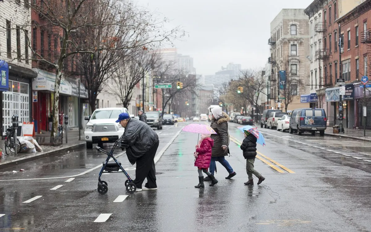 The elderly and families with children cross the street on a rainy day in Greenpoint, Brooklyn, New York, Jan. 14, 2014. Civic hackers have been converting messy NYPD data into useful maps to help communities identify safe and dangerous streets and have meaningful conversations with city agencies. (Samira Bouaou/Epoch Times)