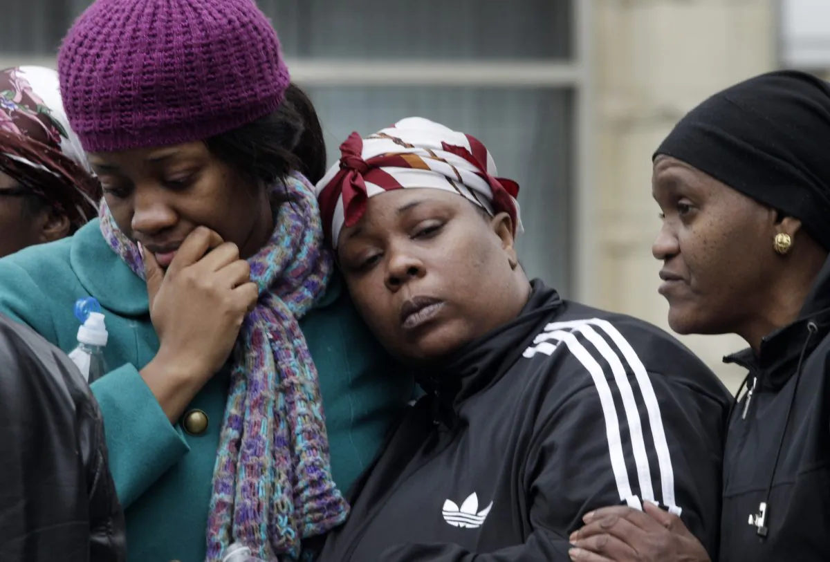 Alecia Thomas (L) is comforted by her friend Shivon Dollar (C) after she lost her home following an explosion that leveled two apartment buildings in the East Harlem neighborhood of New York, March 12, 2014. (AP Photo/Mark Lennihan)
