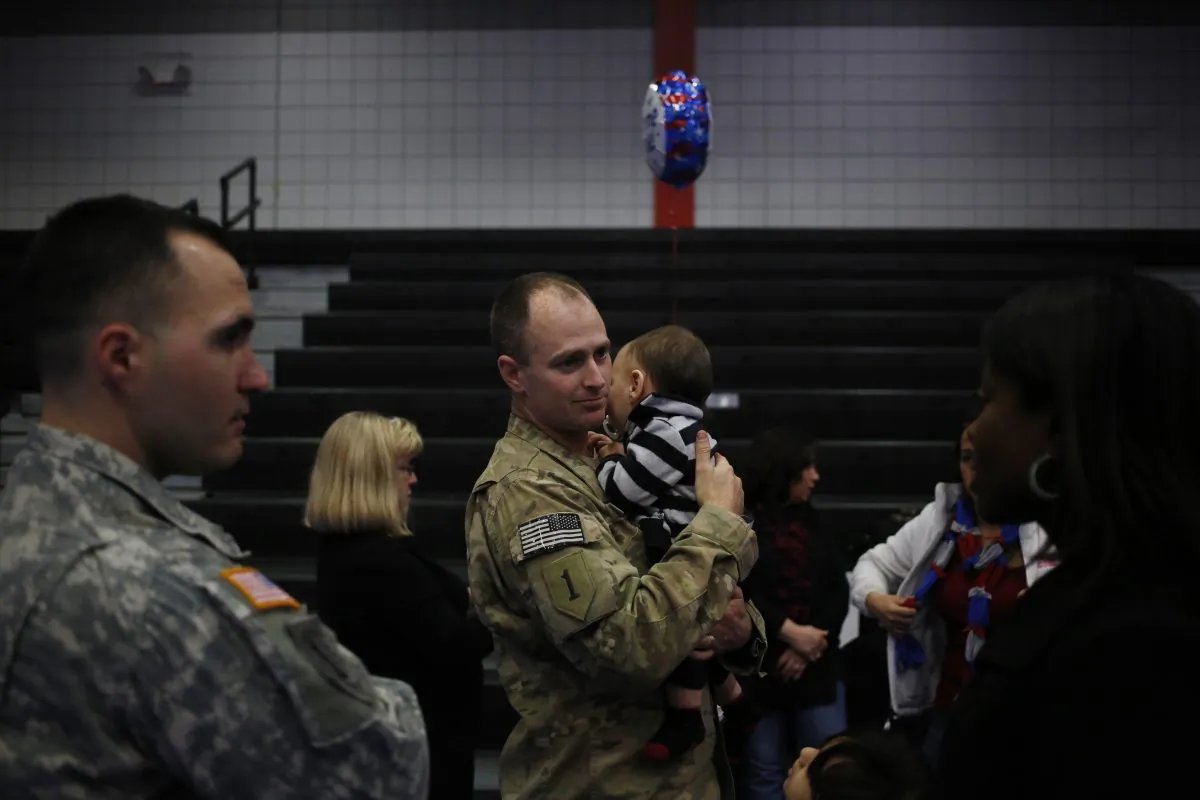 A Staff Sergeant from the U.S. Army's 3rd Brigade Combat Team, 1st Infantry Division, reunites with loved ones and family members following a homecoming ceremony in the Natcher Physical Fitness Center on Fort Knox on Thursday, February 27, 2014 in Fort Knox, Ky. (Luke Sharrett/Getty Images)