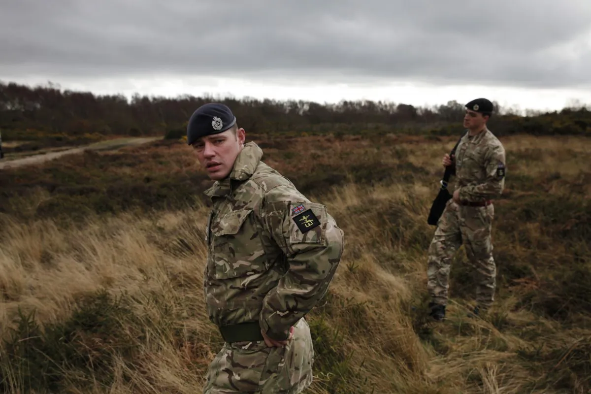 British army officers walk on an area with WW1 practise trenches in Gosport, southern England, Thursday, March 6, 2014. (AP Photo/Lefteris Pitarakis)