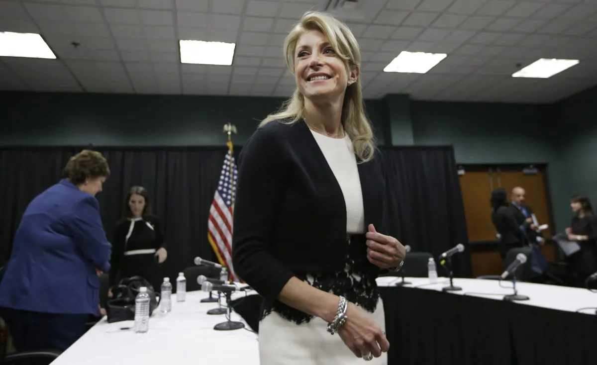 Former Texas Sen. Wendy Davis smiles as she heads to speak to reporters after an education roundtable meeting in Arlington, Texas on Jan. 9, 2014.  (LM Otero/AP Photo)