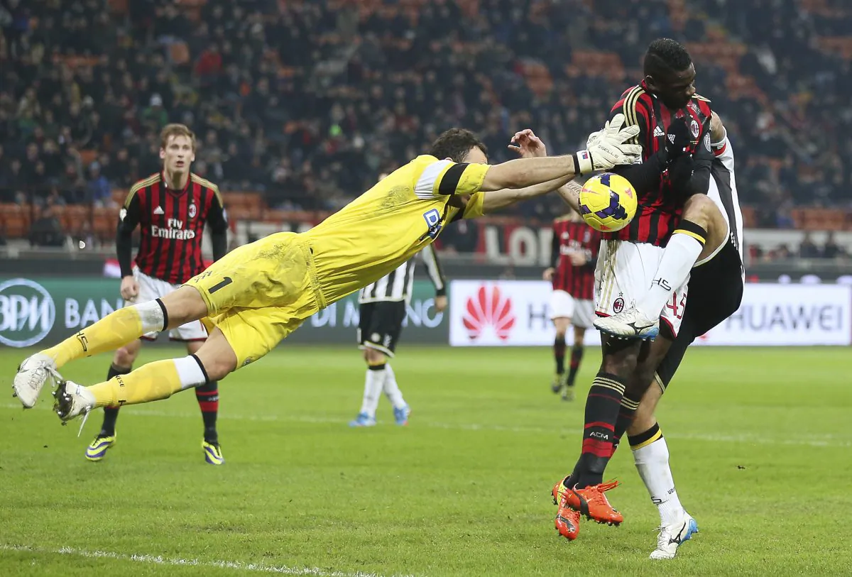 AC Milan forward Mario Balotelli, right, challenges for the ball with Udinese goalkeeper Zeljko Brkic, left, of Serbia, and Udinese defender Maurizio Domizzi during an Italian Cup soccer match at the San Siro stadium in Milan, Italy, Wednesday, Jan. 22, 2014. (AP Photo/Antonio Calanni)