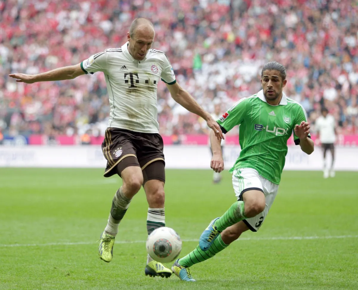 Wolfsburg's Ricardo Rodriguez of Switzerland, right, and Bayern's Arjen Robben of the Netherlands challenge for the ball during the German first division Bundesliga soccer match between FC Bayern Munich and VfL Wolfsburg, in Munich, southern Germany, Sat., Sept. 28, 2013. (AP Photo/Matthias Schrader)