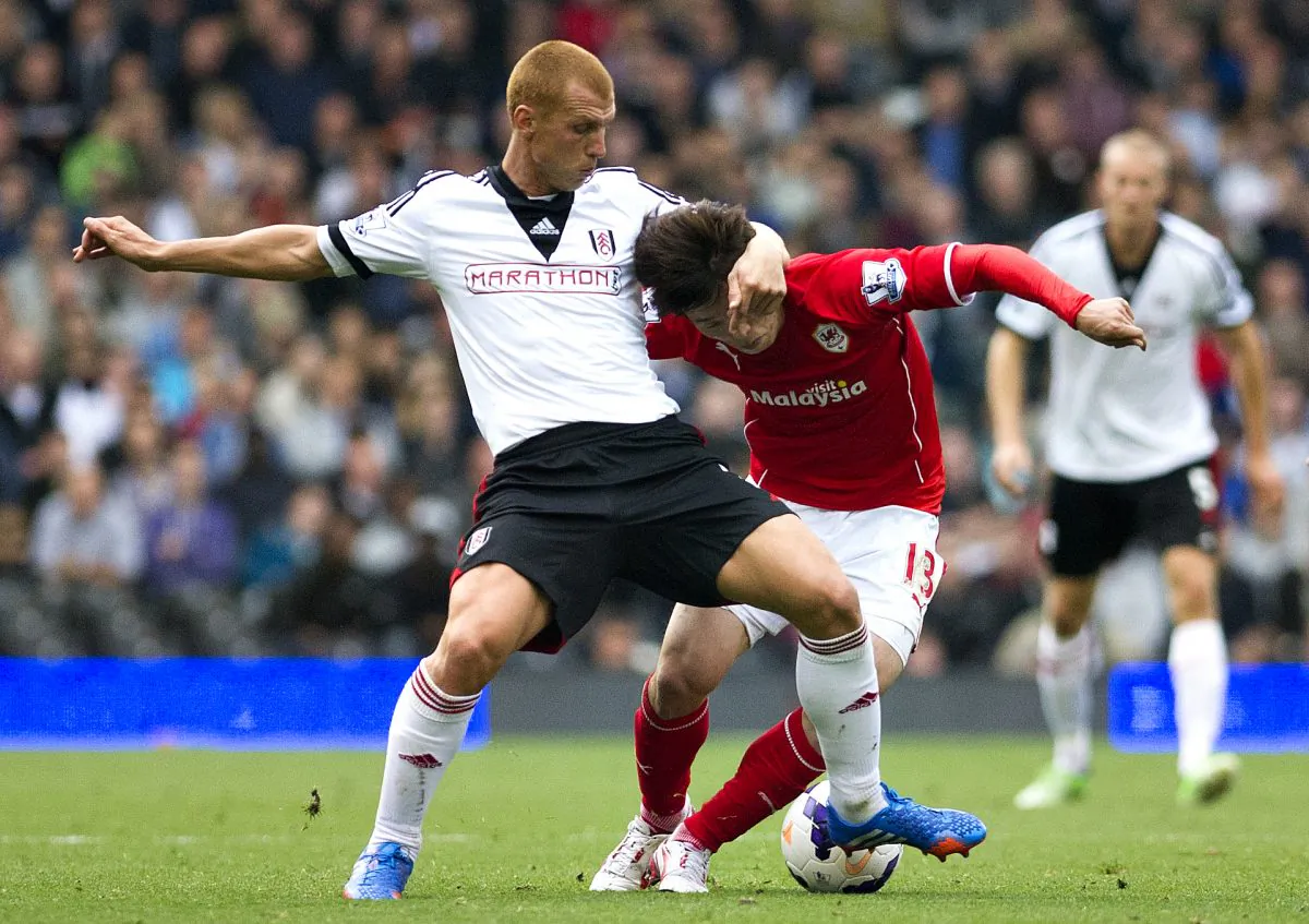 Fulham's Steve Sidwell, left, fights for the ball with Cardiff City's Kim Bo-Kyung during their English Premier League soccer match at the Craven Cottage stadium, in London, Saturday, Sept. 28, 2013. (AP Photo/Bogdan Maran)
