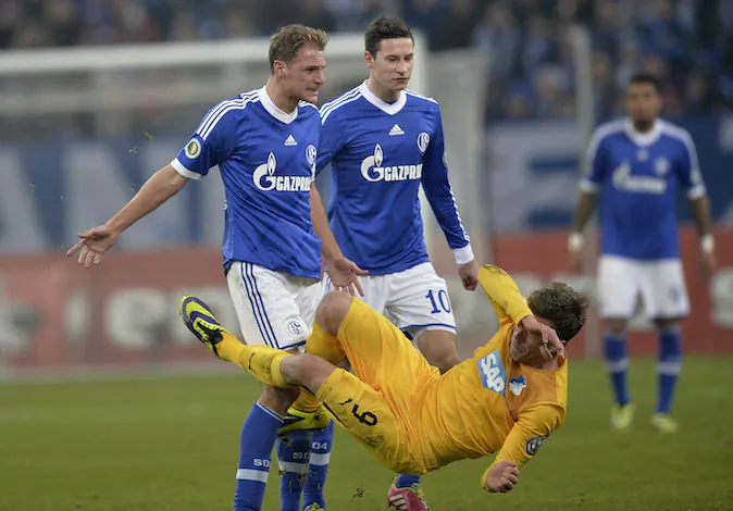 Schalke's Benedikt Hoewedes, left, clashes with Hoffenheim's Sven Schipplock, right, during the German soccer cup third round match between FC Schalke 04 and TSG Hoffenheim in Gelsenkirchen, Germany, Tuesday, Dec. 3, 2013. (AP Photo/Martin Meissner)